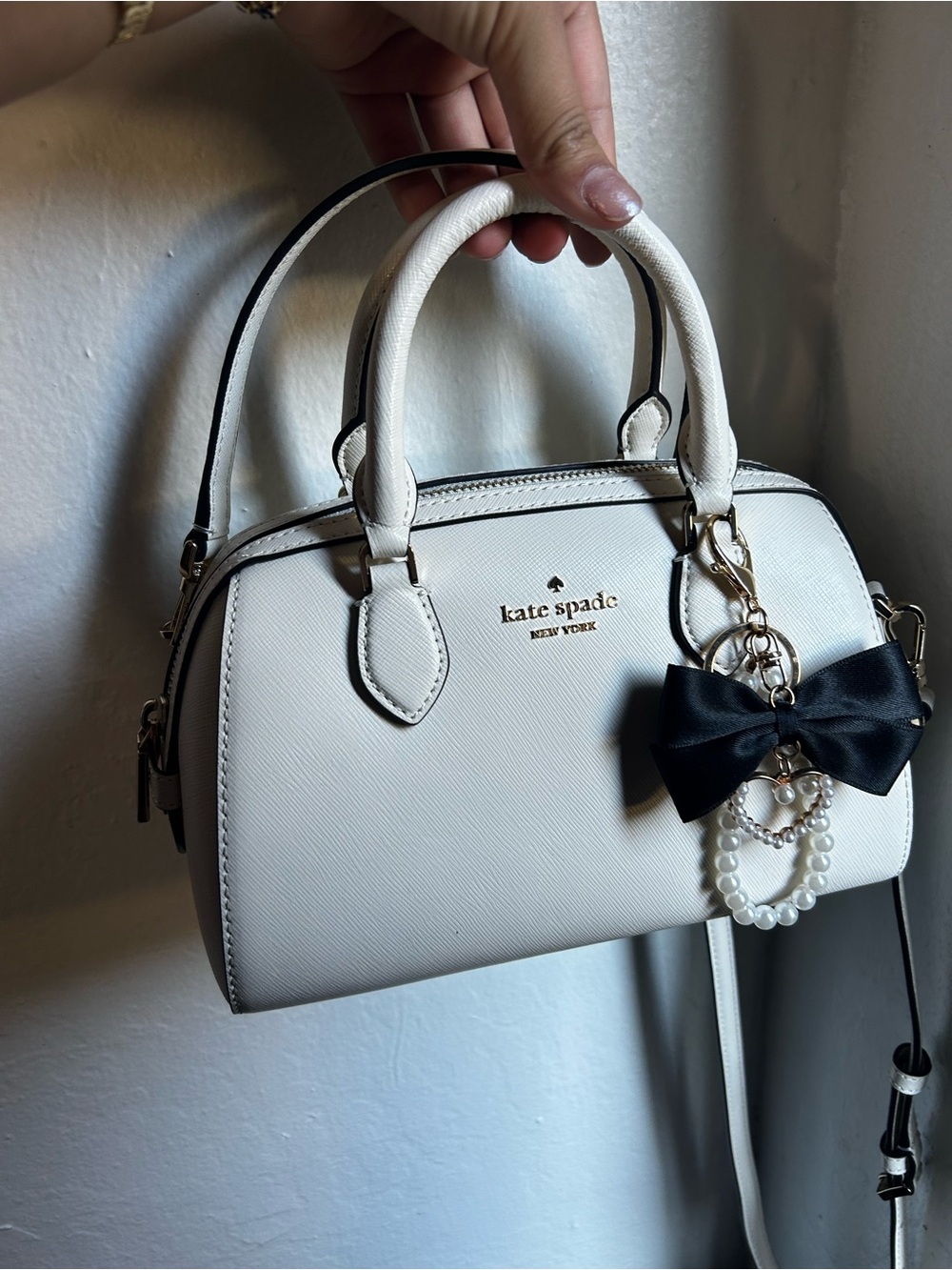 kate spade white satchel with black bow charm